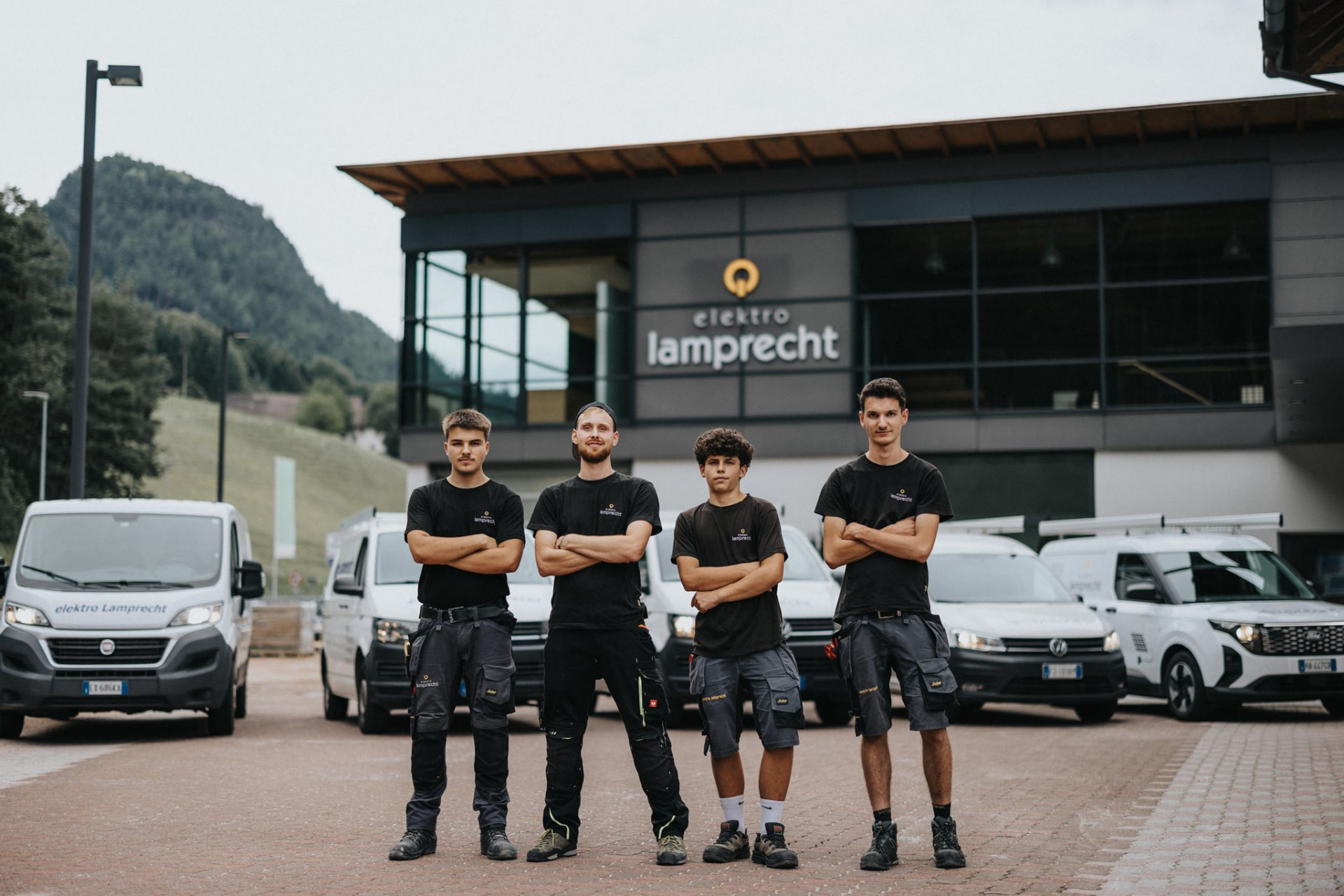 Team von Elektro Lamprecht vor den Firmenfahrzeugen in Vintl